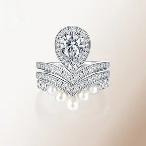 Detailed view of pear-cut moissanite crown ring set with silver band and pearls