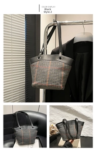 Detail view of plaid tote bag featuring black leather handles and grey check wool fabric