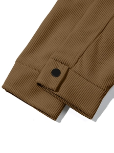 Detailed close-up of brown corduroy shirt sleeve featuring a matte button adjustment strap