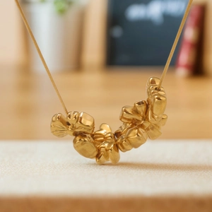 Golden necklace with irregular crushed gold flower pendant on a sleek snake chain
