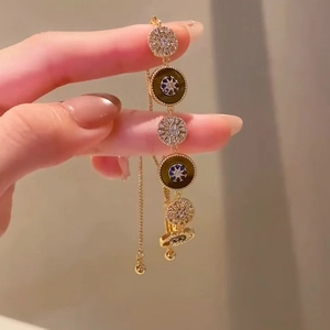 Détail d'un bracelet plaqué or 18 carats avec breloques œil de tigre et zircons brillants
