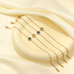 Classic gold stainless steel bracelets with colorful zircon stones on a ceramic plate