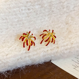 Vue détaillée de la boucle d'oreille fleur en émail rouge et cristaux sur tissu blanc