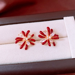 Macro detail of red enamel floral earrings with 18k gold plating and zircon crystals