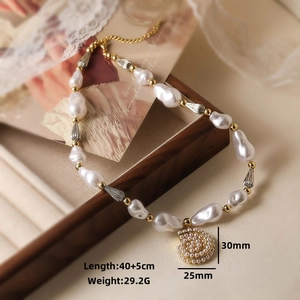 Macro view of vintage baroque pearl necklace with snail pendant and product dimensions