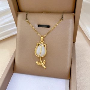 Macro shot of gold tulip pendant necklace with white gemstone in jewelry box