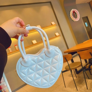 Close-up of white heart-shaped PVC jelly bag with classic quilted pattern and round handle