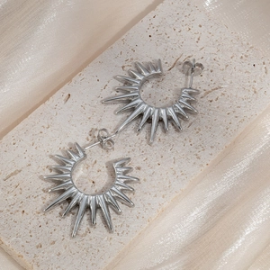 Boucles d'oreilles créoles soleil en argent sur socle en pierre avec fond en soie