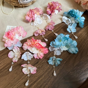 Détail de l'épingle à cheveux en fleurs de soie faite main avec de longs pompons et perles