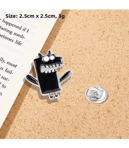 Detail of cartoon monster enamel pin with dimensions 2.5x2.5cm and butterfly clasp