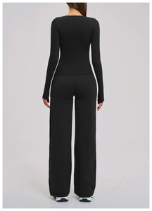 Back view of slim fit black yoga set featuring long sleeve top and wide leg trousers