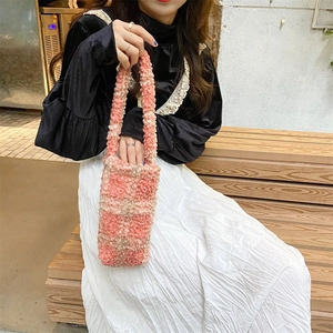 Close-up of pink and beige checkered plush tote bag with soft faux shearling texture