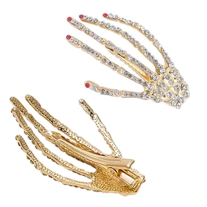 Paire de barrettes main de squelette dorées avec strass et pointes de doigts rouges