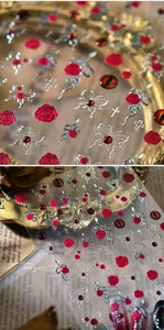 Macro detail of Gothic nail stickers with dark red roses and metallic embossed silver snakes