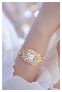 Macro view of women's gold square watch with crystal-encrusted bezel and Roman numerals