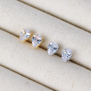 Minimalist 6-12mm teardrop zircon studs in gold and silver finish on beige jewelry box