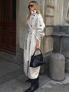 Detail of high collar and double-breasted buttons on cream faux leather trench coat