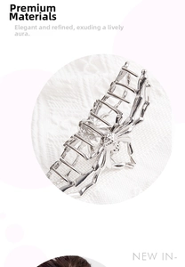 Detail shot of a silver metal spider hair claw clip with fine textures on lace fabric