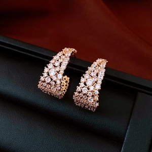 Vue détaillée des boucles d'oreilles en forme de U en or rose avec zircons blancs brillants