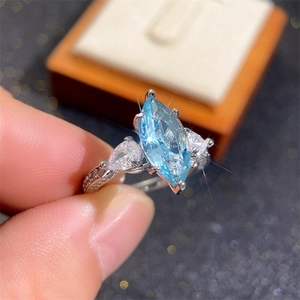 Copper ring with marquise light blue zircon and pear side stones in a hand display