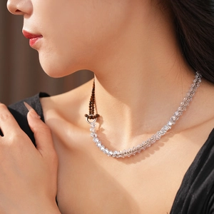 Detailed view of zircon tiger eye heart necklace with silver chain and brown beads on a model