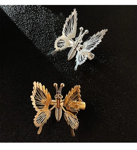 Detailed view of gold and silver hollow metal butterfly hair clips with intricate textures