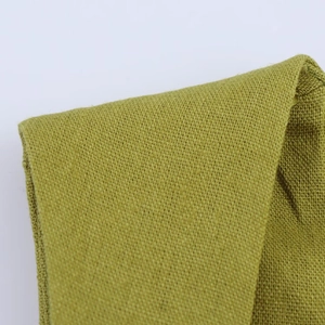Detalle macro de vestido de punto verde hierba que muestra textura de tejido liso