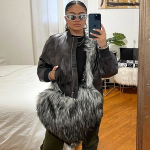 Detail of grey faux fur crossbody bag styled with a vintage leather bomber jacket