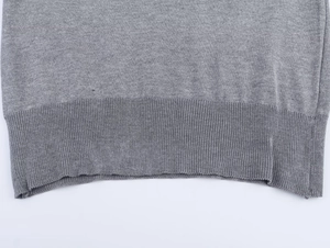Detailopname van de geribbelde zoom en grijze gebreide textuur van deze dames top met korte mouw