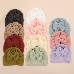 Mise à plat de turbans à nœud pour bébé en onze couleurs incluant rose et tons neutres