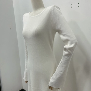 Detail of white slim-fit knitted long-sleeved dress showing fabric texture and back cut