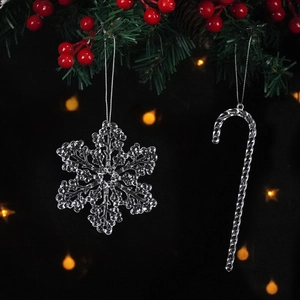 Close-up of clear acrylic snowflake and candy cane ornaments hanging on a Christmas tree