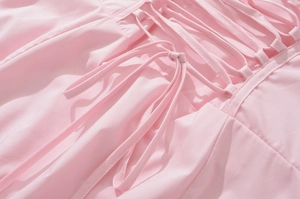 Detail shot of the back lace-up closure and soft pink fabric on a French retro dress