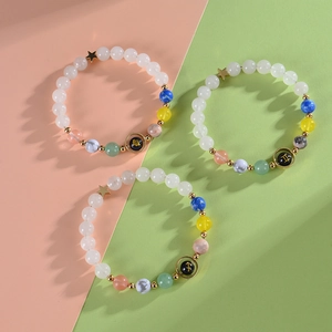 Three beaded zodiac bracelets with white beads and colorful stones on a split background