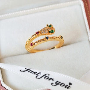 Detailed view of a gold snake ring set with colorful zircon stones in a gift box