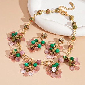 Vintage gold jewelry set with green beads and pink circular stone pendants