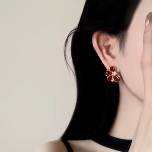 Élégantes boucles d'oreilles fleurs rouges plaquées or 18 carats portées par un mannequin