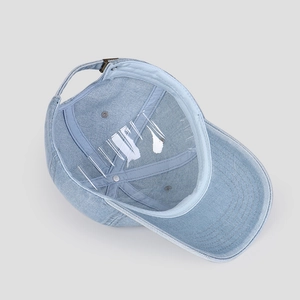 Detailed inner view of washed denim baseball cap with adjustable metal buckle and stitching