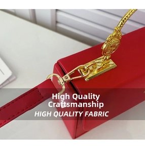 Détail de boucle dorée et breloque dragon sur le sac à main en cuir rouge élégant