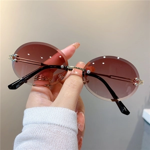Détail de lunettes de soleil ovales sans monture avec verres dégradés et branches en métal