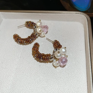 Detail of C-shaped earrings with brown seed beads, white pearls and pink crystal drops
