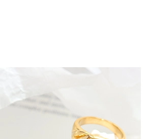Detailed close-up of a twisted gold knot ring featuring a metallic polished finish