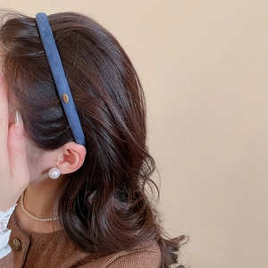 Détail d'un serre-tête bleu en velours avec accents dorés et accessoires en perles