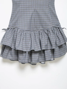 Detail showing blue and white plaid layered ruffle hem with cotton linen texture
