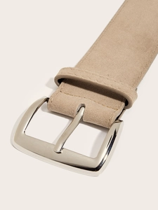 Detailed close-up of a khaki suede belt with a polished silver metal buckle