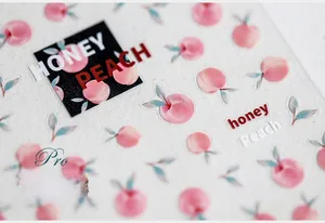 Macro detail of peach nail stickers with 3D embossed texture and honey peach lettering