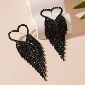 Dark gothic heart earrings with long crystal tassels on a minimalist stone background