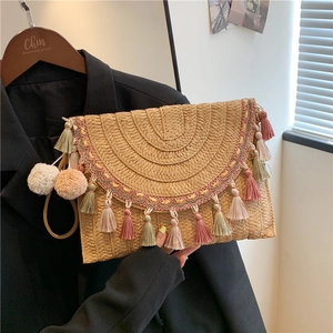 Straw bohemian clutch with colorful tassels and pompoms for beach vacations