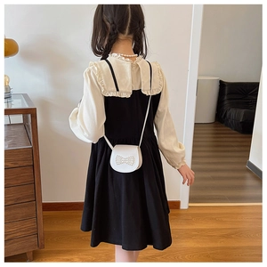 Detail view of the dress back with invisible zipper and a white pearl bow purse
