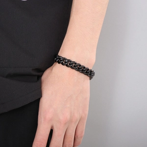 Close-up of a masculine black stainless steel Cuban link bracelet on a male wrist